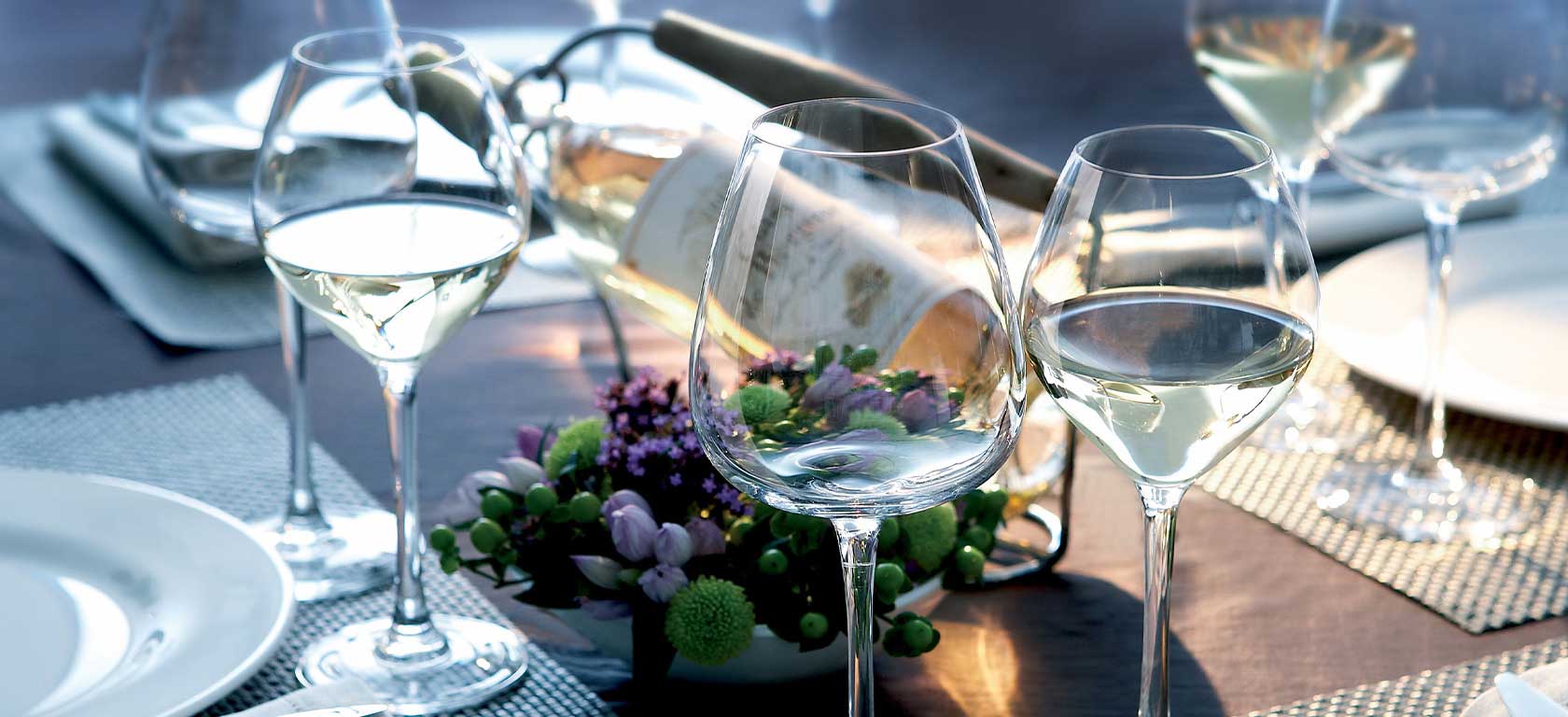 Delicate looking empty wine glasses in a tastefully decorated table.