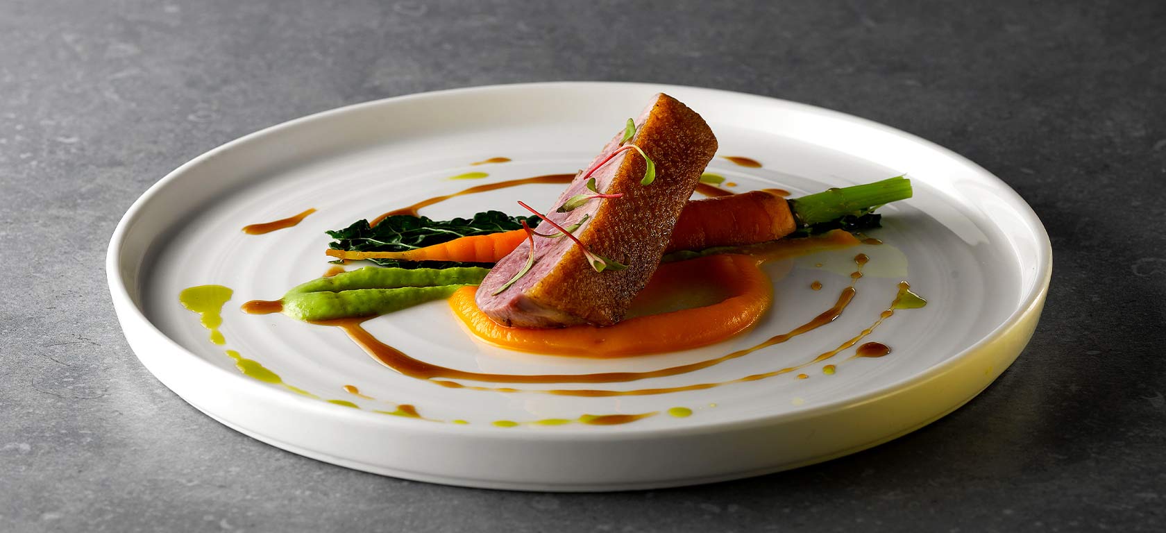 Tender salmon and asparagus plated delicately over an elegant white ceramic plate.