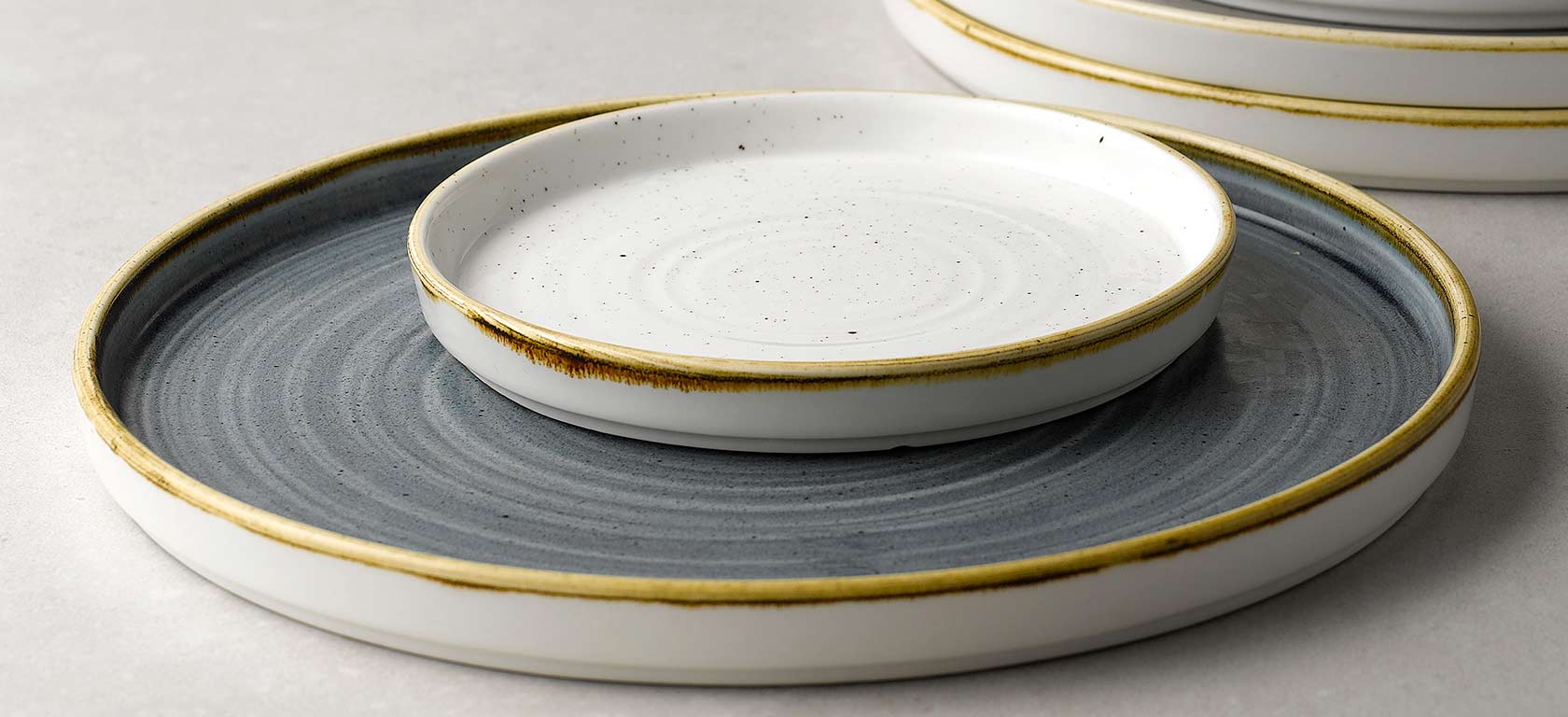 Gold trimmed ceramic plates with circular indents.