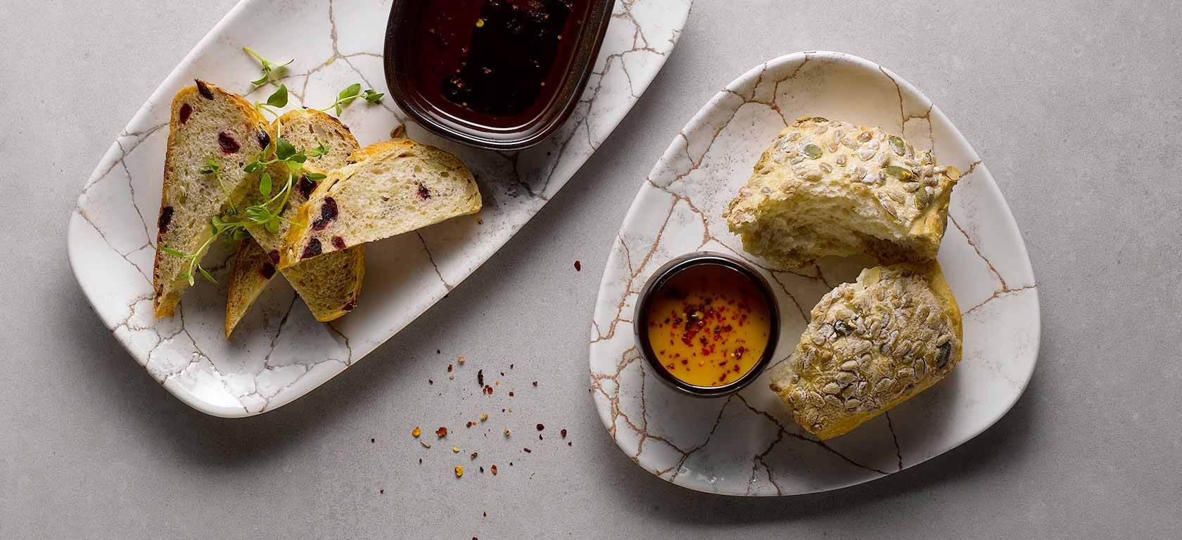 Rustic cracked plates with an assortment of nutty bread and sauces.