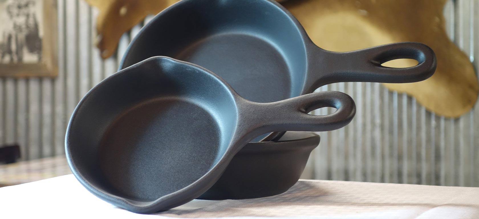 Large and small black ceramic griddles and pans.