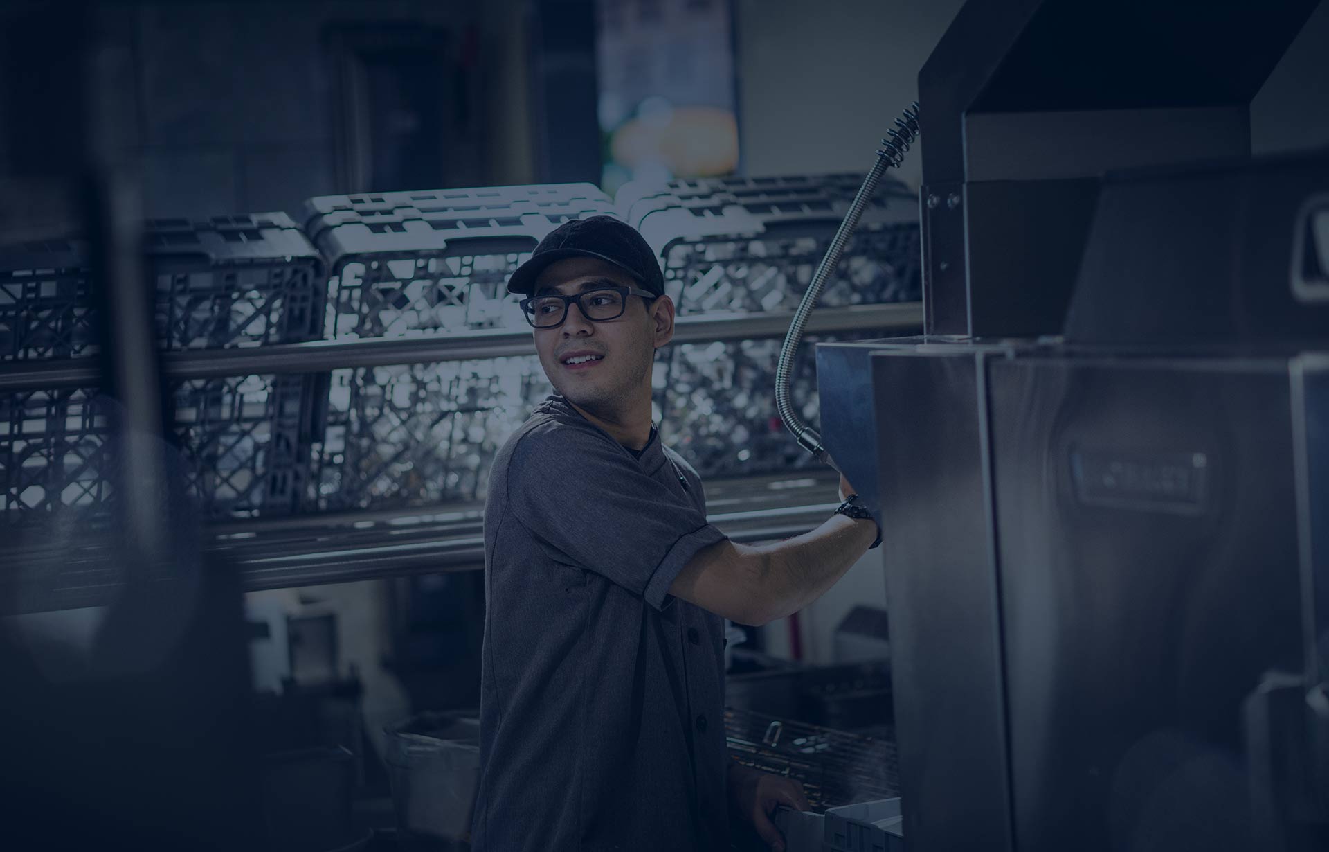 Active kitchen worker in hat and glasses multi-tasking.