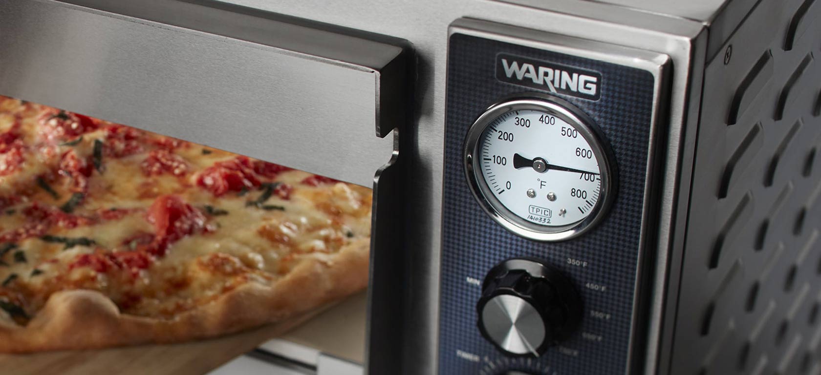 Waring toaster oven with chrome finish warming a flatbread.